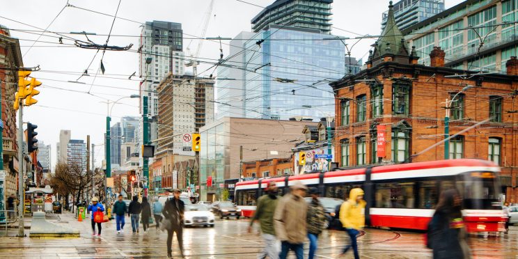 Busy intersection of Queen and Spadina in Toronto on a rainy day.