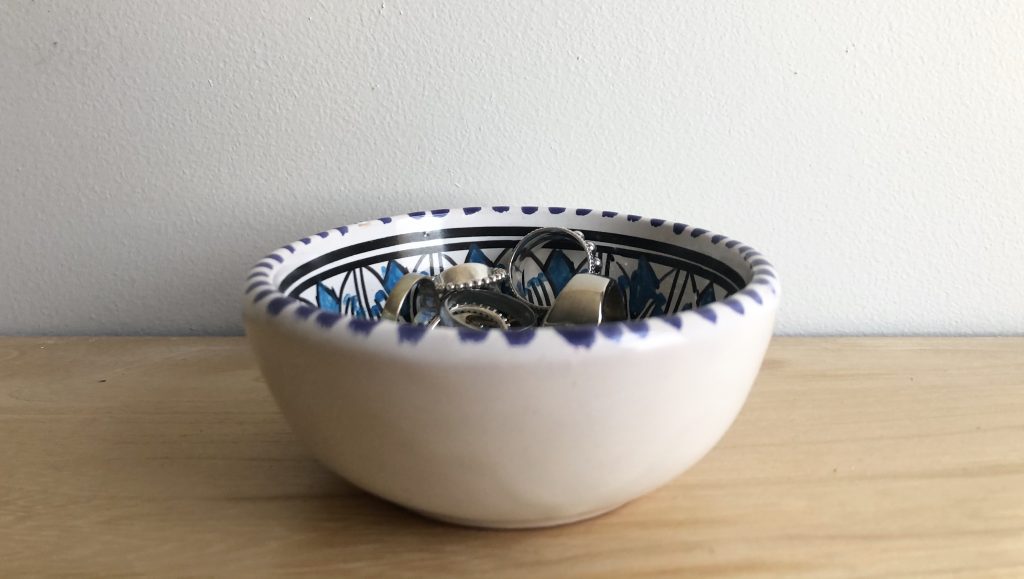 a small bowl that is white on the outside and has a pattern on the inside with rings in it 