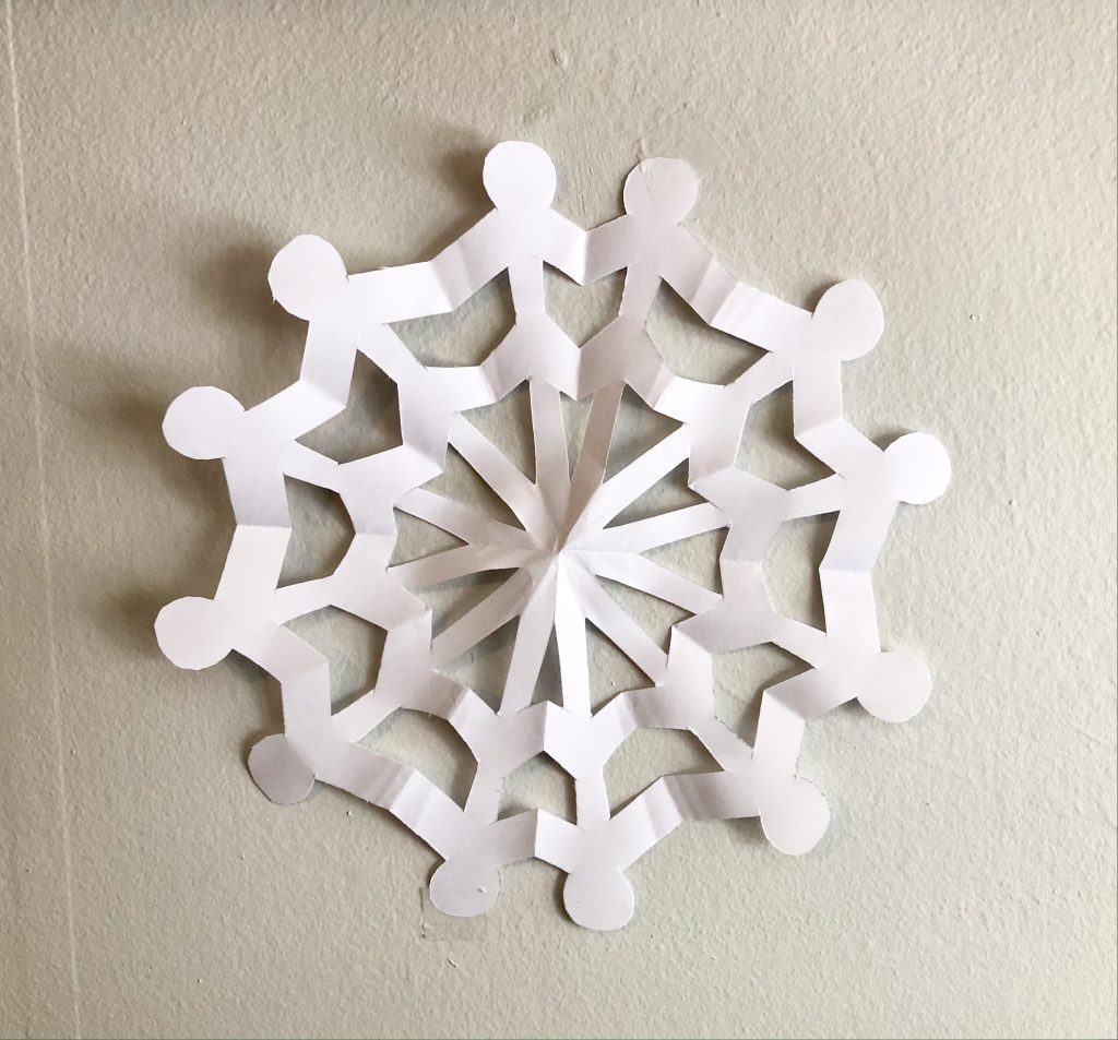 a snowflake cut-out taped to a white wall
