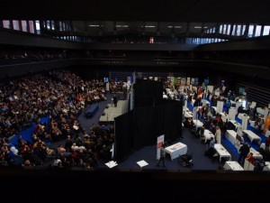 Convention room filled with people and showcase booths