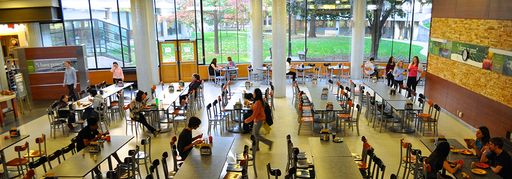 A dining hall that is filled with students connecting with one another.