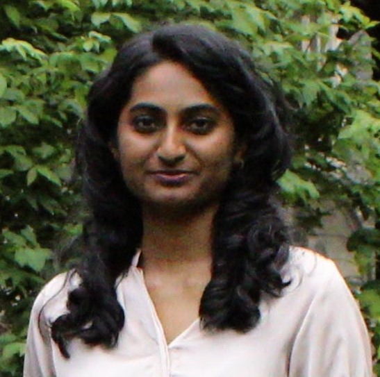 Thaksha smiling against backdrop with trees