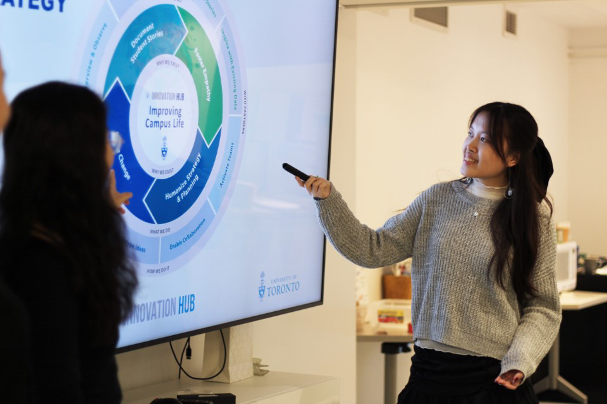 A person pointing at a TV with data on the screen