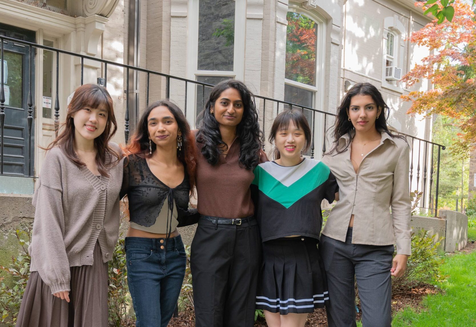 A photo of Reception experience at health & wellness Team, featuring five members standing outdoors, smiling at the camera.