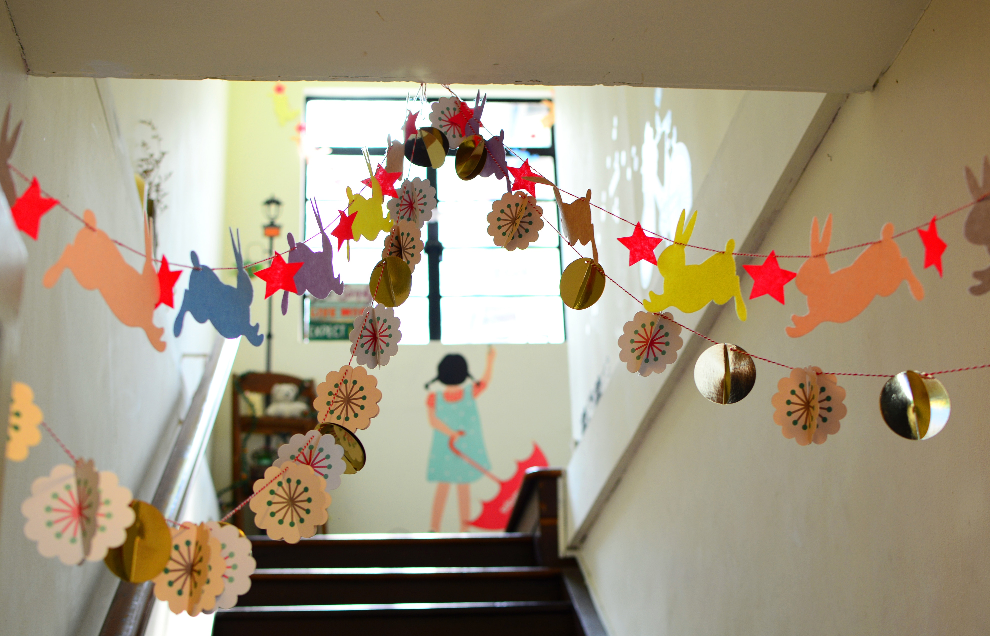 girl standing at the top of the stairs in an elementary school hallway with decorative banners in the foreground