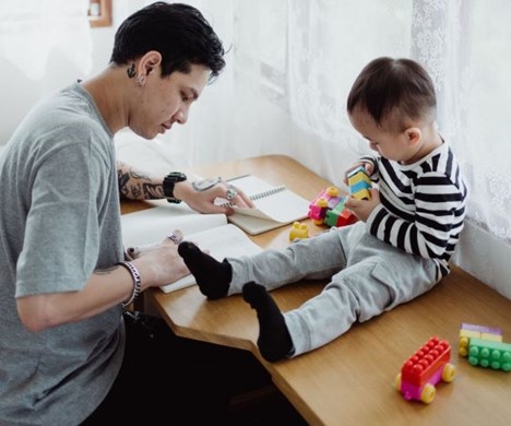 Student studying with toddler playing on desk