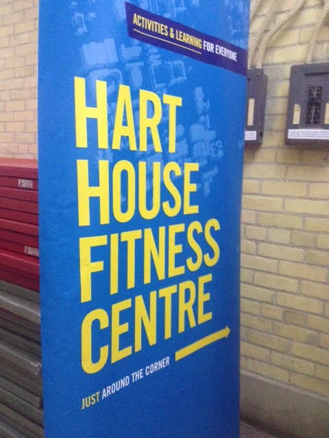 Photo of banner saying "Hart House Fitness Centre" with and arrow pointing down the hall.  