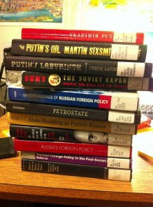 A massive stack of eleven thinck Russian Foreign Policy books from Robarts. Putin's picture is glaring at me from one of them.