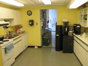 Looking outwards from the back of the First Nations House, with a large coffee machine on the right and a countertop and sink to the left