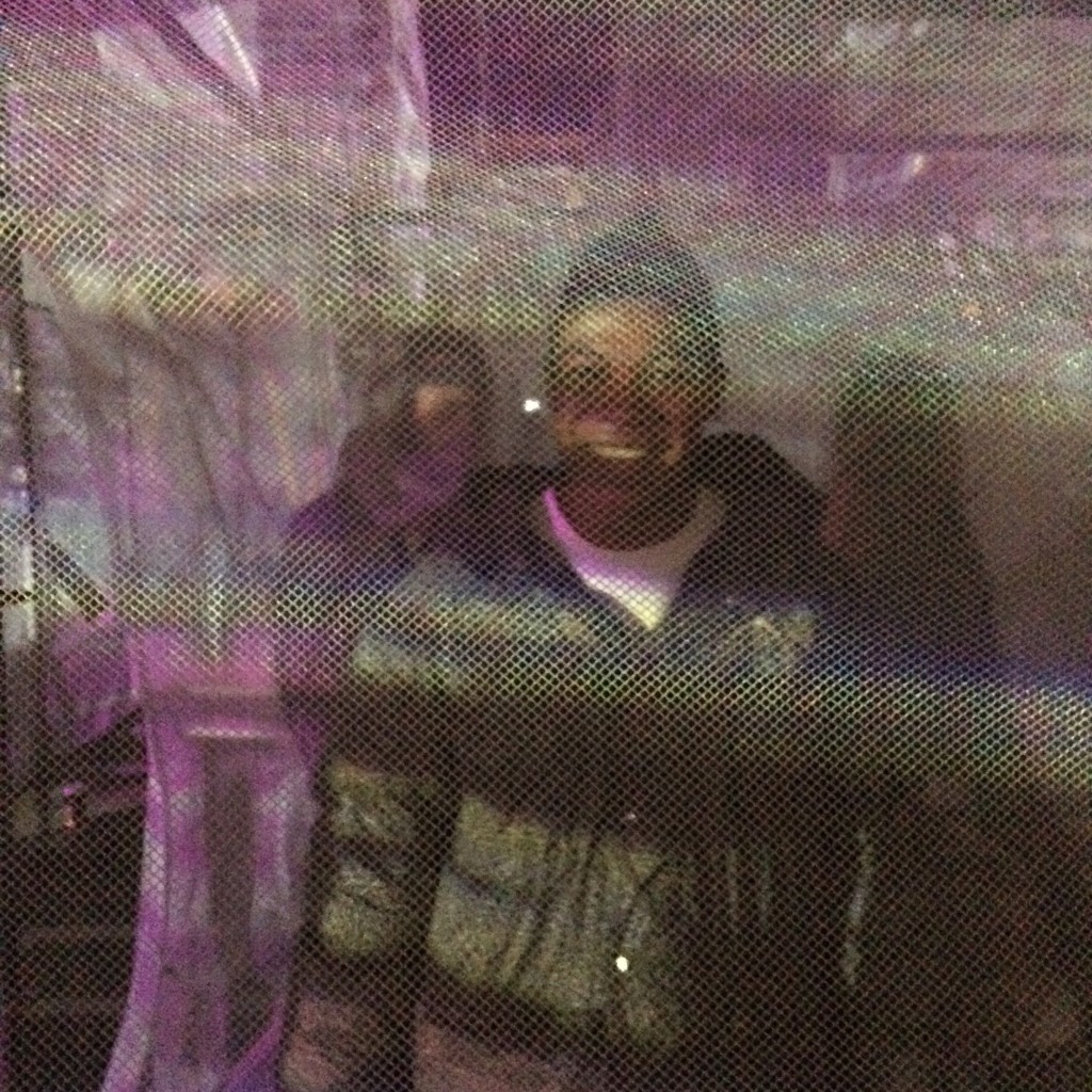 A picture of me smiling in a maze-like art installation. 