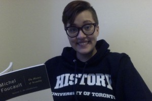 Haley with a U of T "History" hoodie holding Michel Foucault's "A History of Sexuality- Volume 1." Foucault is a notoriously difficult philosopher to understand.