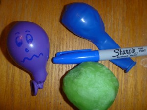 A photo consisting of a balloon, a balloon filled with flour, and a sharpie. 