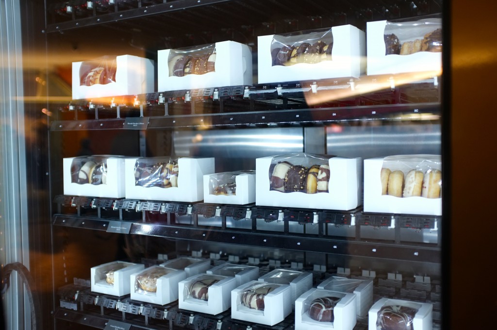 a close up of the inside of the baked goods vending machine, three rows of donuts and macarons