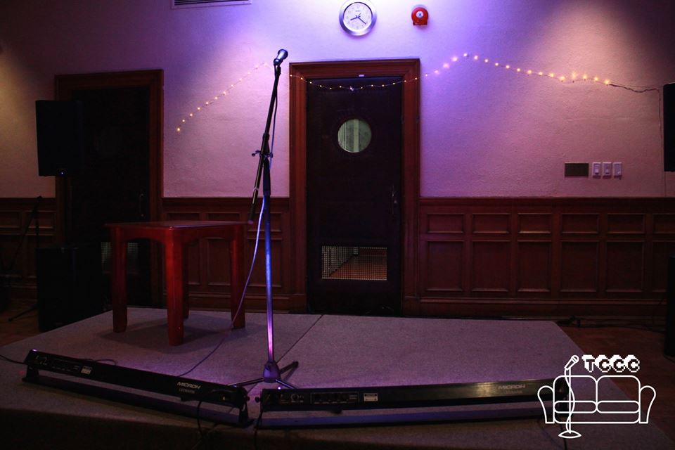 A picture of our empty stage. It has wonderful purple lighting and white string lights surrounding the background.