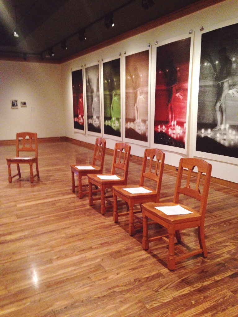5 chairs are set up in a line in front of colourful artwork
