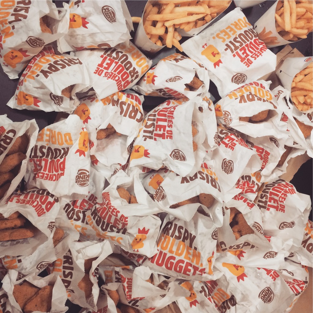 A picture of like 400 Burger King chicken nuggets with some fries. 