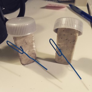 Two battered erasers with paperclip guns and bottle cap helmets