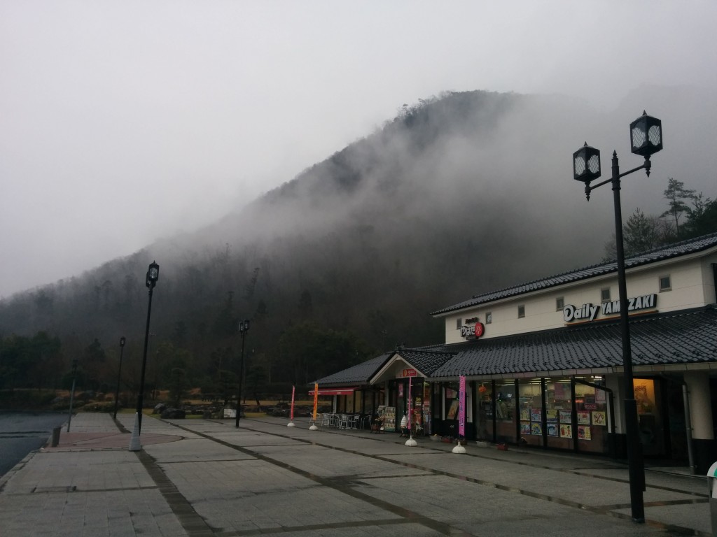 This image shows a service station in Japan. A mountain covered in mist can be seen in the background.