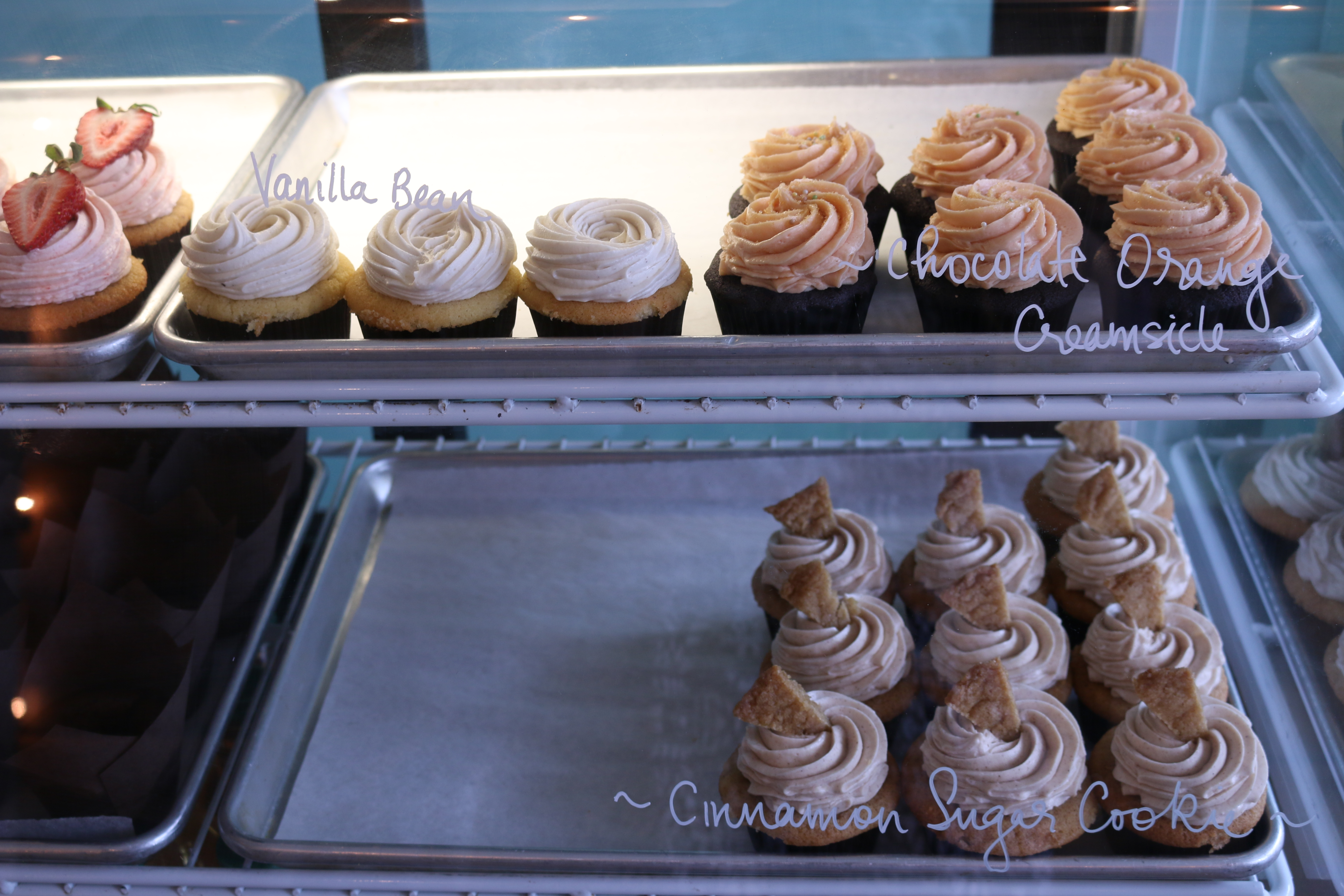Cupcakes inside Almond Butterfly. Flavours from left to right, top row: strawberry milkshake, vanilla bean, orange creamsicle, cinnamon sugar cookie.  