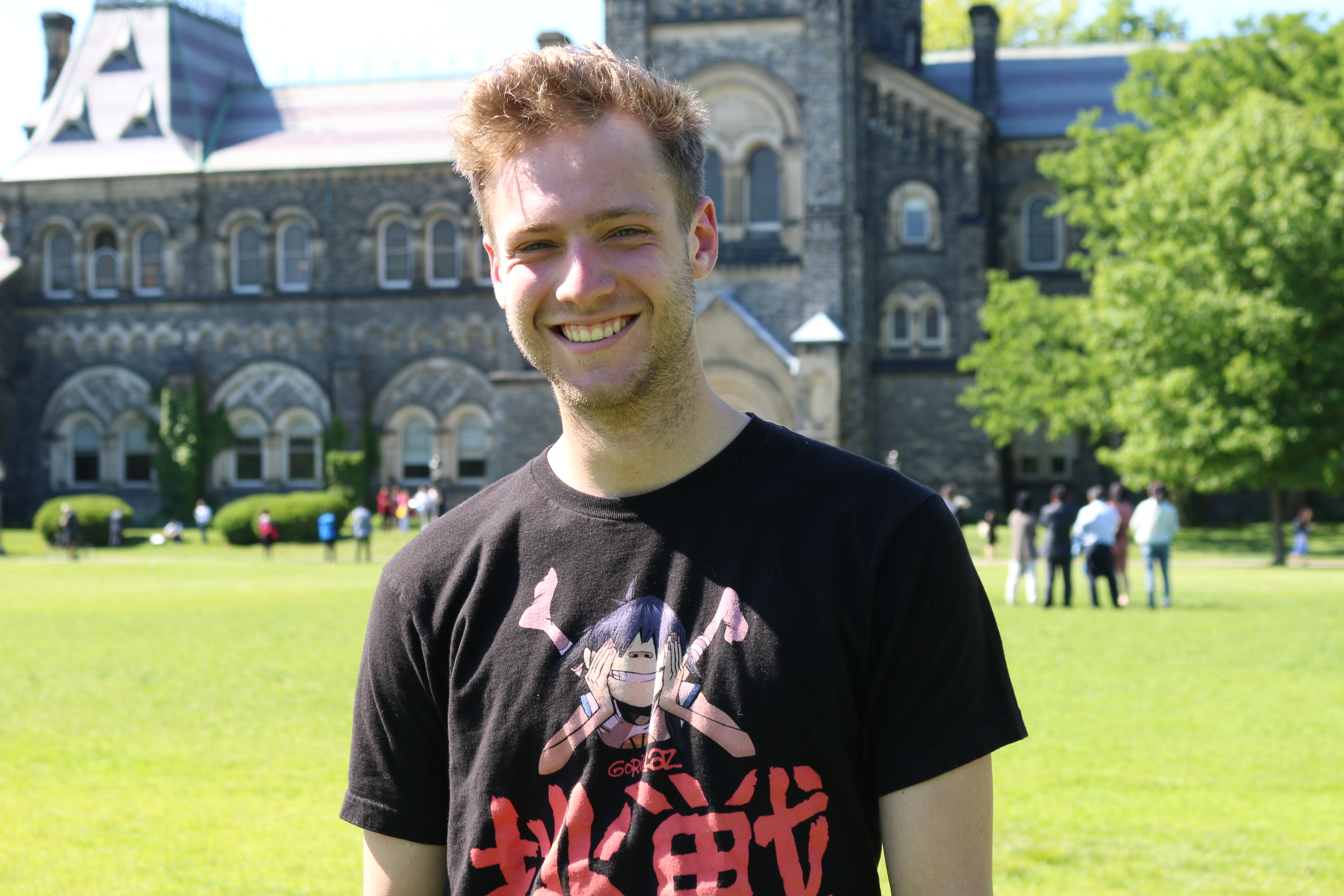 A portrait of Matthew in front of University College on Front Campus.