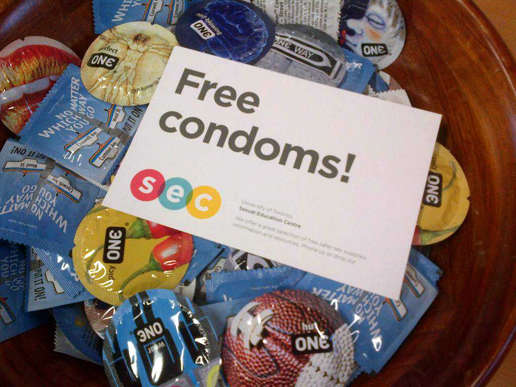 picture of a bowl of condoms with a sign that says "free condoms" on top