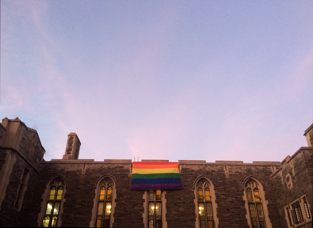 photo of one wall of hart house with a pride flag attatched to it 