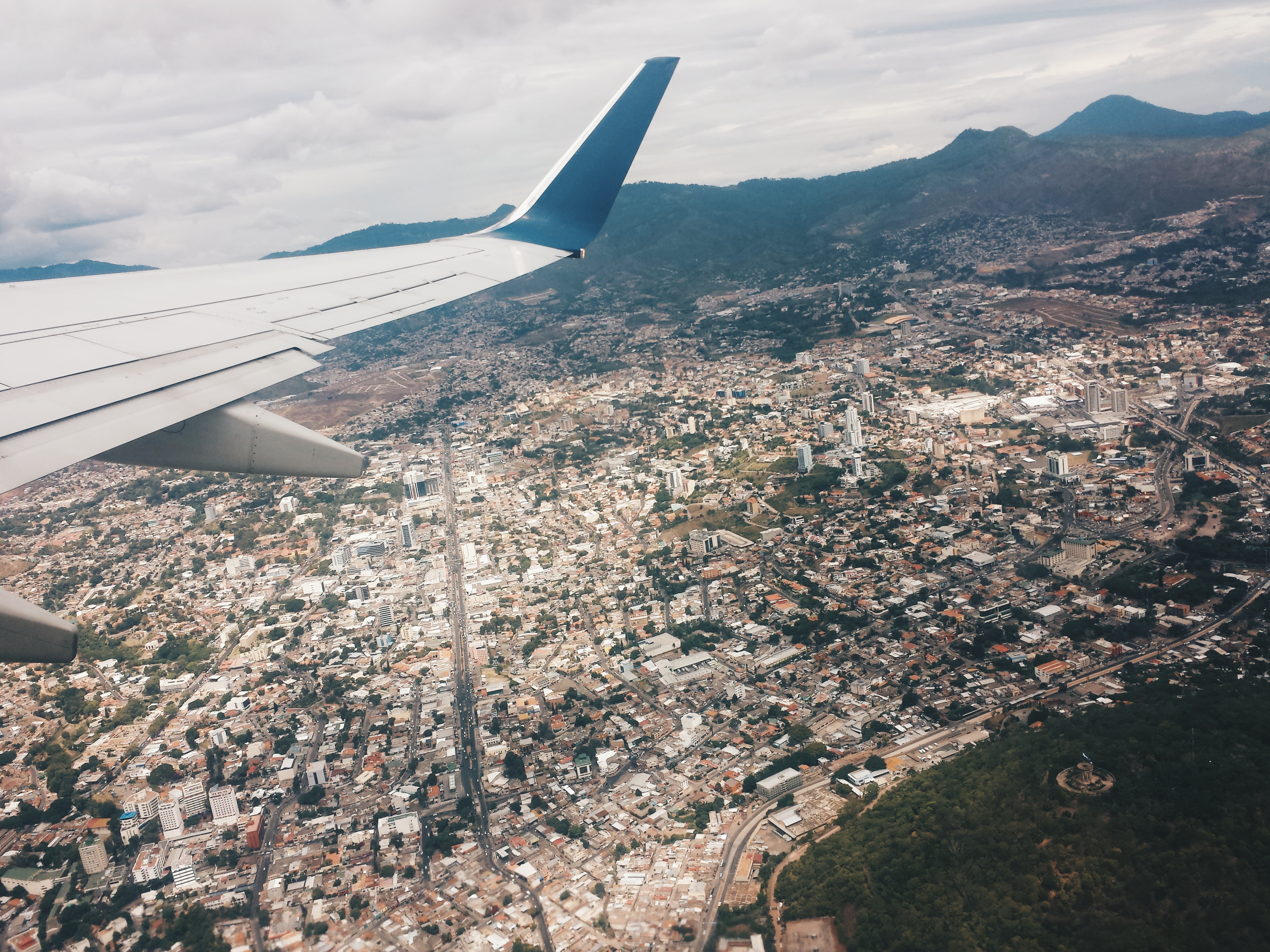The capital of Tegucigalpa can be seen under our plane's wing. The sprawl of the city is littered with lowrise houses and the warm tones of clay roofs. In the background are the lush green mountains that are so characteristic of the Honduran landscape.