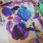 a piece of paper covered in blobs of blue and purple paint