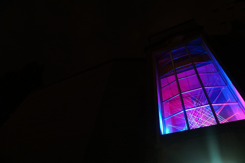 photo of UTS window with strings lit up by lights 