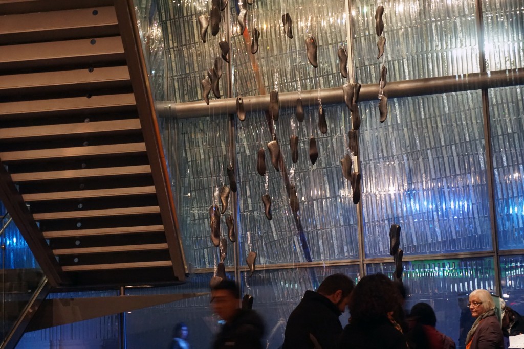 photo of concrete sculptures of shoes hanging from a ceiling 