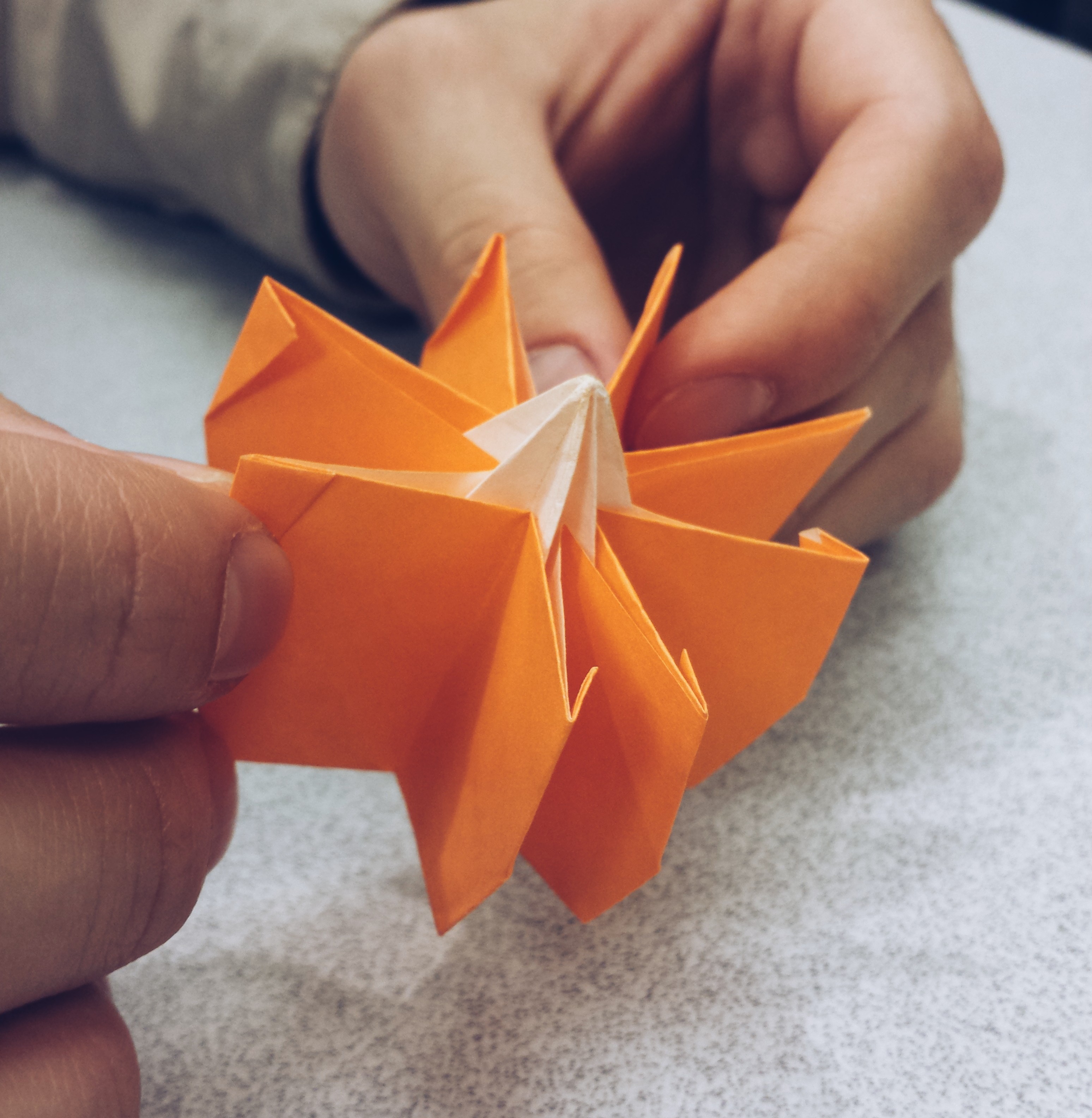 My friend Johnny folding an origami orange pumpkin for the Halloween workshop.