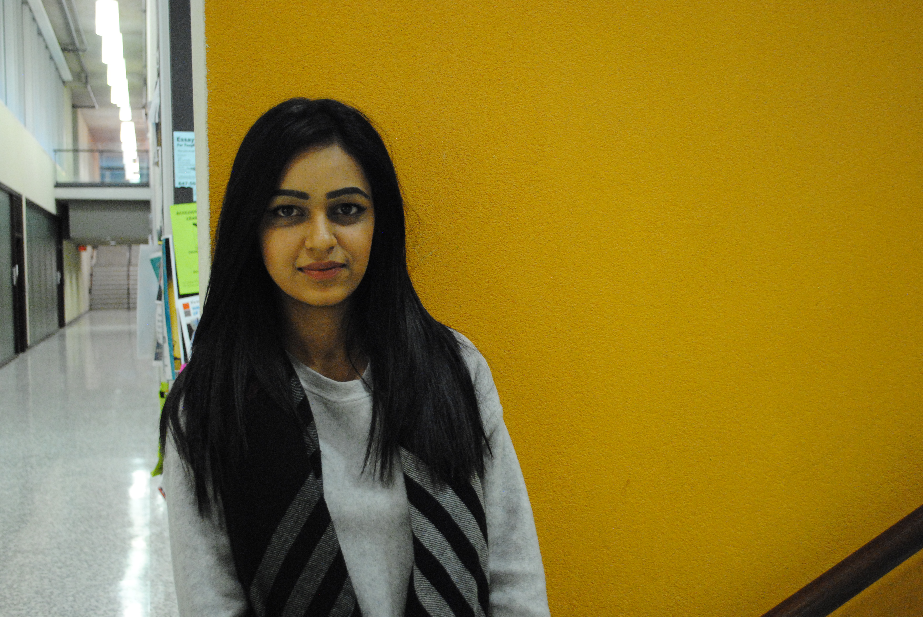 Rida in front of a yellow wall in the Bahen building.