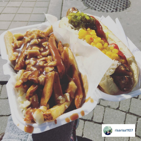 Hot dog and poutine in Styrofoam box from a street vendor.