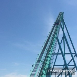 a photo of a rollercoaster car going up the initial drop