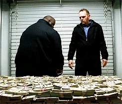 Huell from Breaking bad laying down on a stack of money