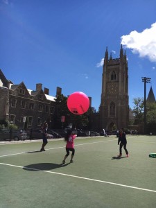 Students are pictured passing an oversized inflatable ball back and forth.