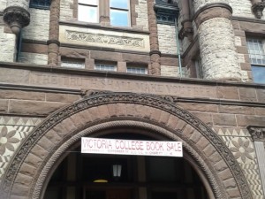 Photograph of entrance to Victoria College building with the Victoria College Book Sale banner hanging from the entrance
