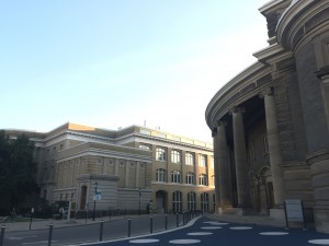 a photo of the pillars of convocation hall and the sanford fleming building beside the convocation hall with the road in between and blue skies above