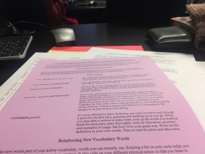 a photo of a stack of colourful paper handouts with a purple sheet of paper on the very top