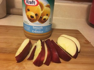 Picture of sliced apples next to a jar of peanut butter