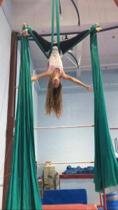 Annette is shown suspended from aerial silks.