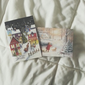 Two Christmas cards lying on a bed