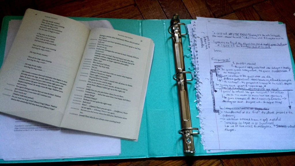 a collection of papers littered with black handwriting, next to an open playbook-both resting atop a bright blue binder