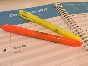 Photo of agenda page with 1 orange highlighter, 1 yellow highlighter lying on top