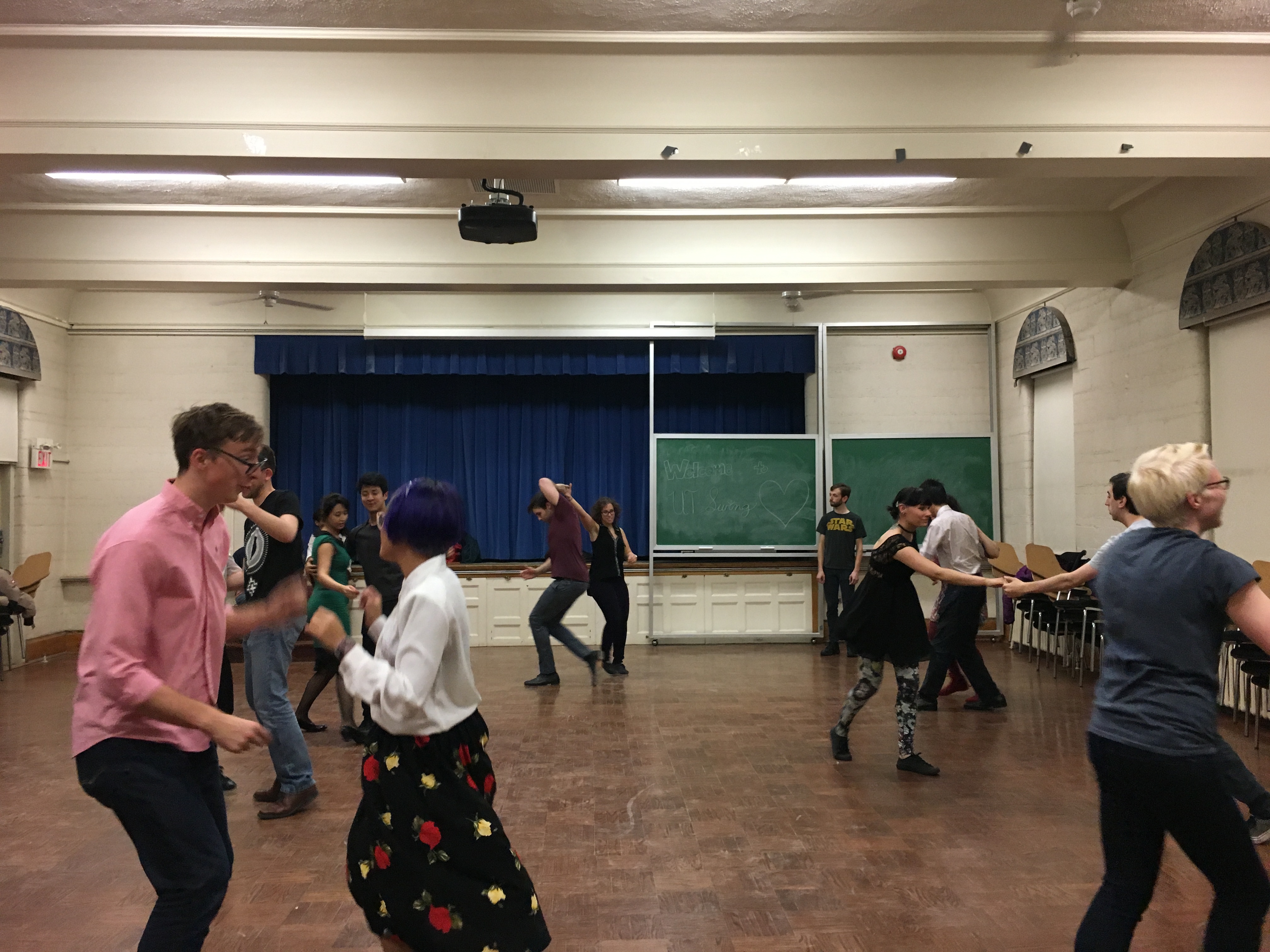 a group of people dance in pairs.
