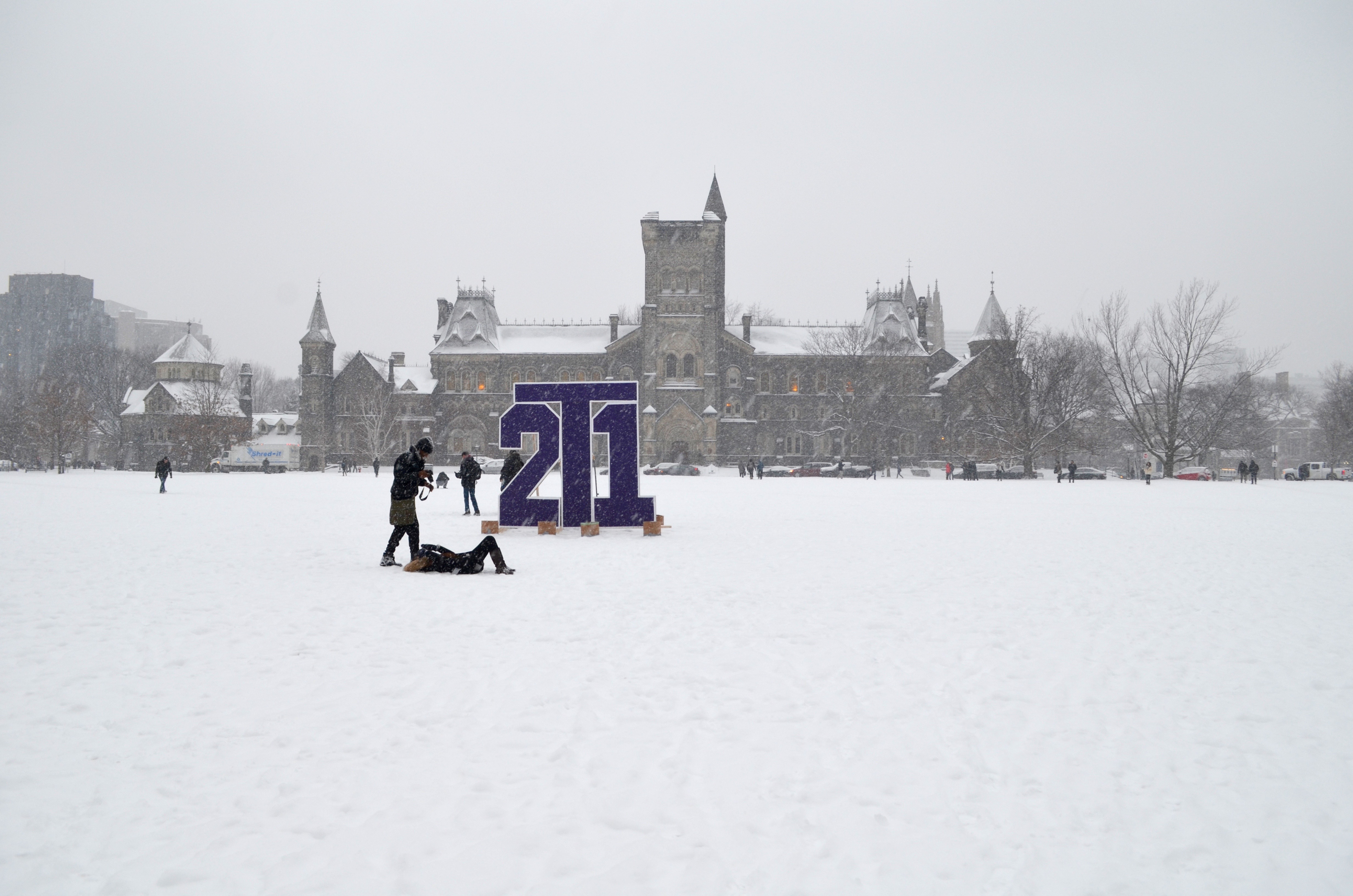 UC during snow time with a purple "2T1" sign on front campus field