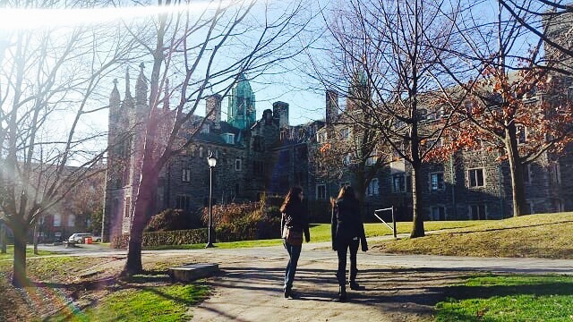 Emi and her friend walking on Trinity grounds.