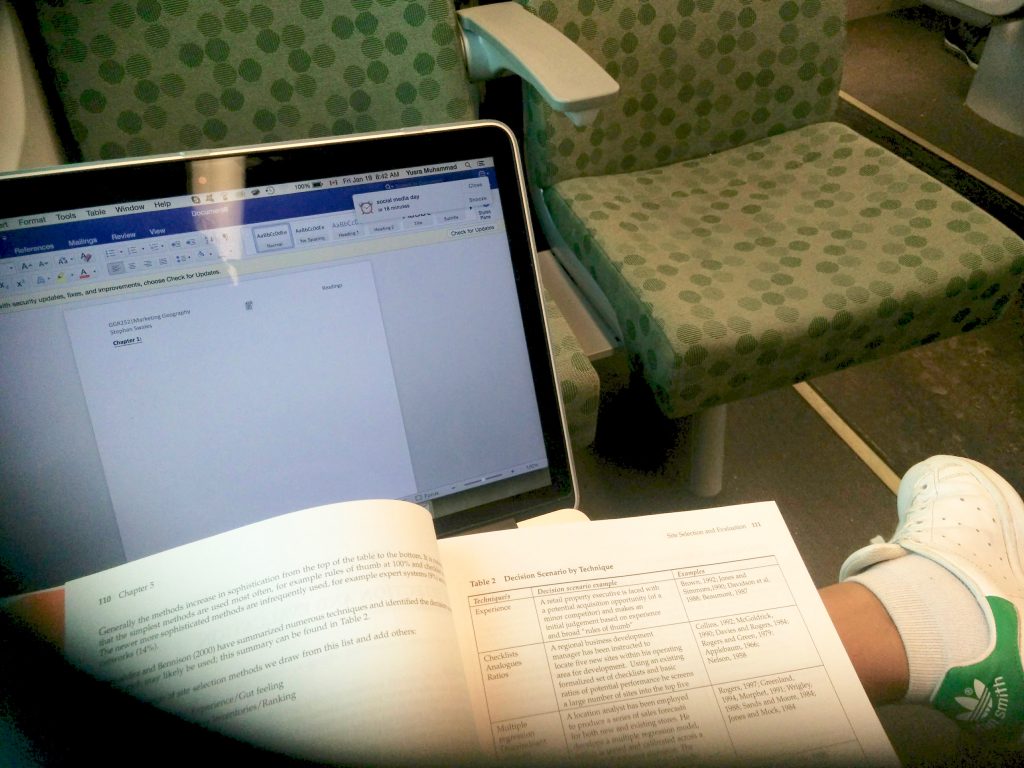 studying with my book and laptop on the GO train seats