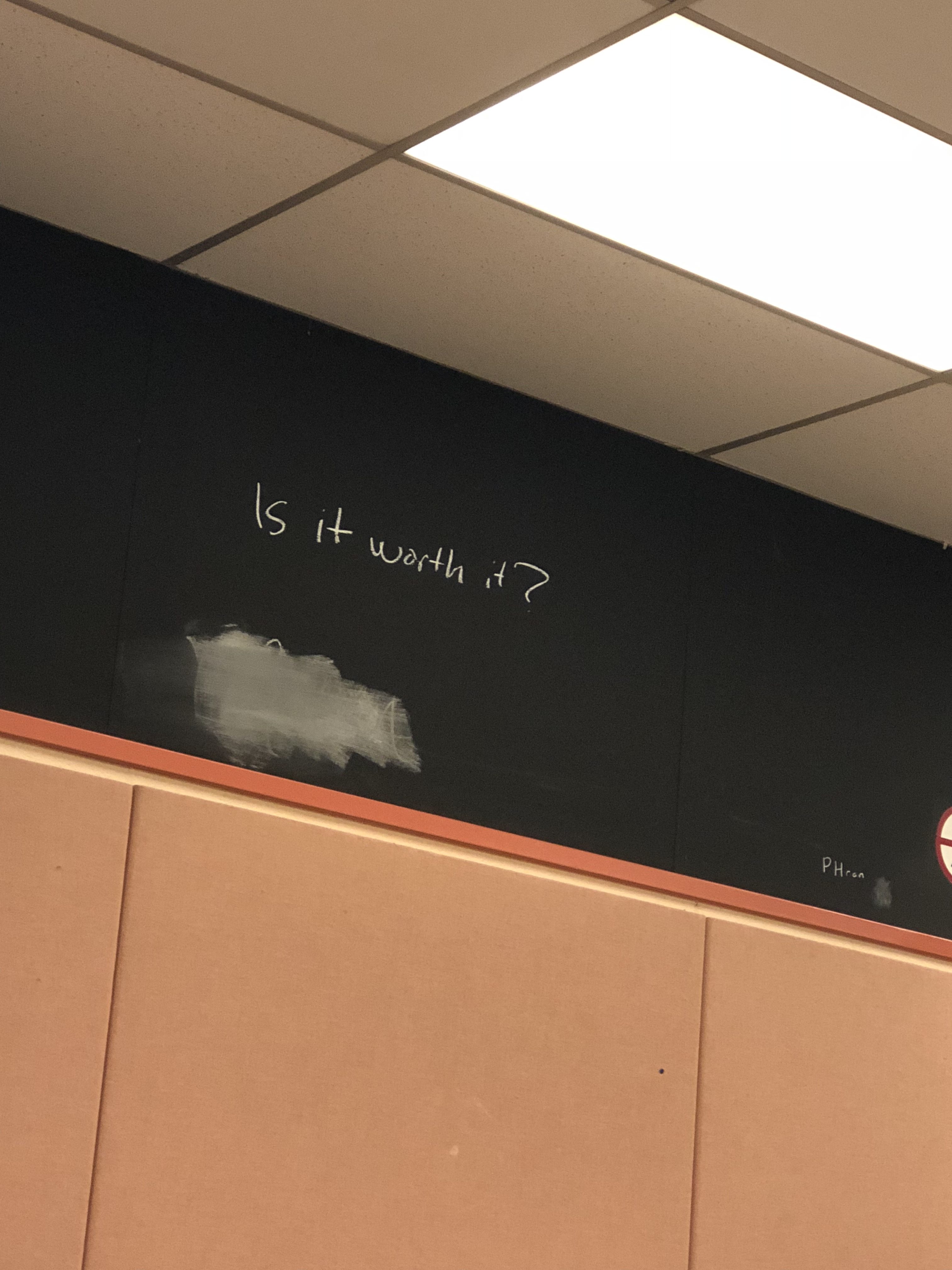 "Is it worth it?" written on a blackboard in a classroom in Sidney Smith Hall