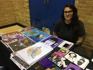 Haudenosaunee Artist Monique Aura at her booth during the Ryerson powwow. Featured on the table are her prints for sale. 